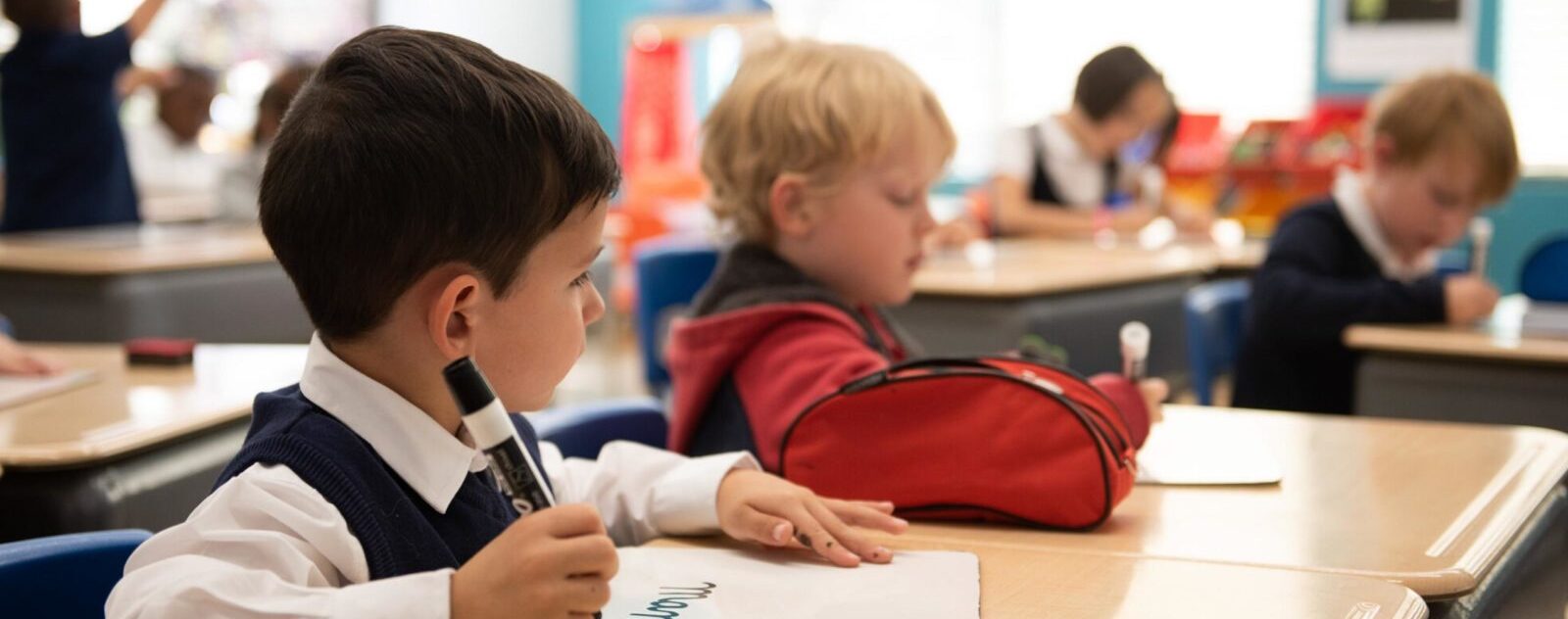 School boy working in class